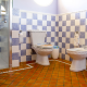 Baño con suelo de baldosa en diagonal, enmarcada en azulejo blanco